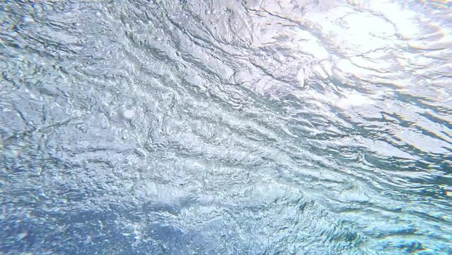 Underwater view of clear ocean wave breaking over corral reef. spinning vortex. powerful nature, strong wave.  Abstract bubbles texture, pattern, slow motion 4k.