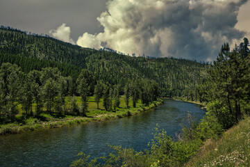 2021-06-17 THE ST JOE RIVER IN IDAHO WITH LUGH GREEN TREES AND A CLOUDY SKY