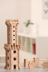 Wooden tower, animals and fence on table indoors, space for text. Children's toys