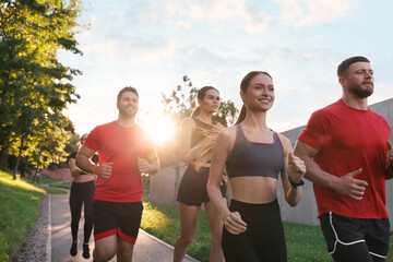 Obraz premium Group of people running outdoors on sunny day