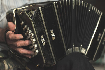 Closeup of a black bandoneon in the process of playing - obrazy, fototapety, plakaty