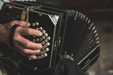 Closeup of a black bandoneon in the process of playing