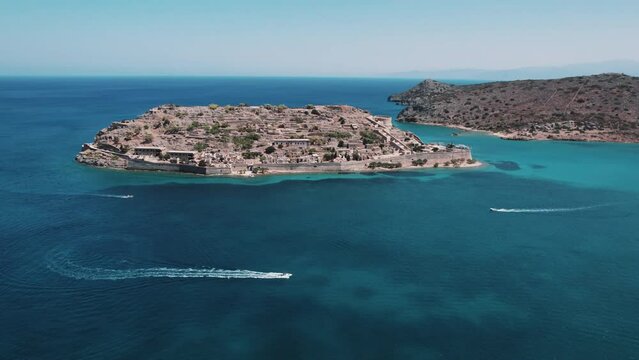 Small Greek island - Spinalonga. Aerial drone view of the Leper Island. Clear turquoise seawater surrounding an islet. High quality 4k footage