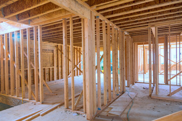 Unfinished house construction with wooden framing beams work in progress view