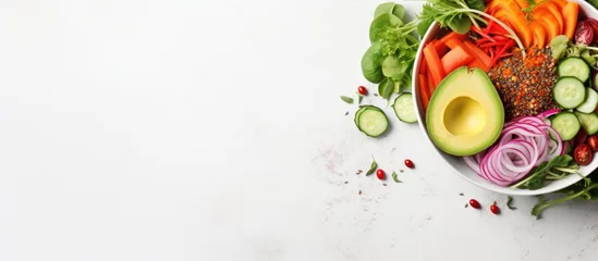 Fototapeten Top view of a white background showcasing a bowl filled with a variety of fresh raw vegetables including cabbage carrot zucchini lettuce watercress salad cherry tomatoes avocado nuts and po © TheWaterMeloonProjec