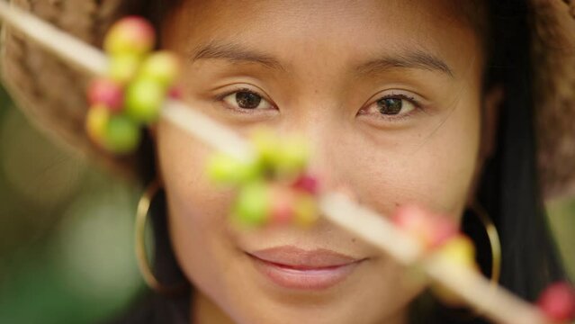 Portrait of smiling female asian arabica coffee farmer on farm, coffee berries