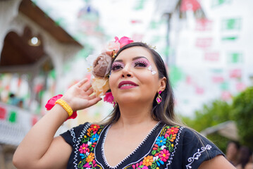 Street portrait of Mexican woman wearing traditional dress with multicolored embroidery. Hispanic woman celebrating independence day.