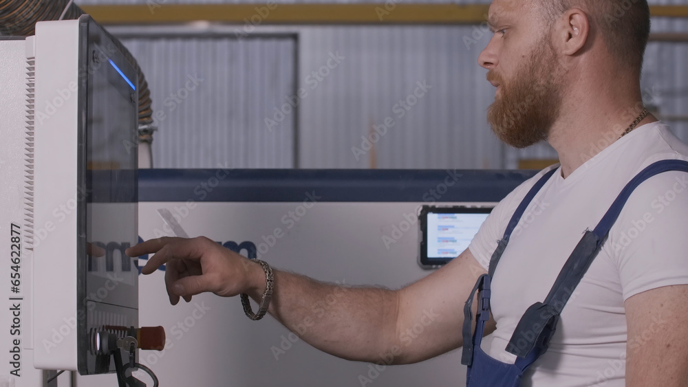 Aufkleber man clicks on control panel of factory. creative. man in uniform adjusts panel at factory. factory e