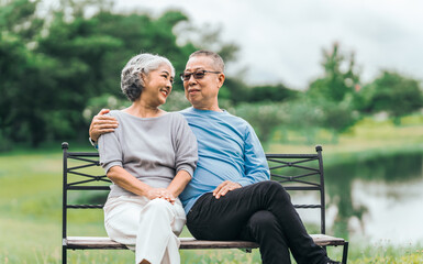 Asian people mature husband and wife, seated on chairs, elderly couple, seated in the park on...