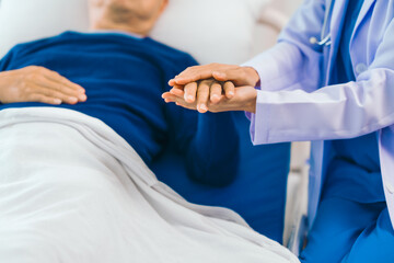 Caring female doctor provides attentive medical care to asian people elderly man lying in hospital bed, highlighting importance of expert healthcare and support during times of illness.