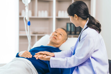 Caring female doctor provides attentive medical care to asian people elderly man lying in hospital...