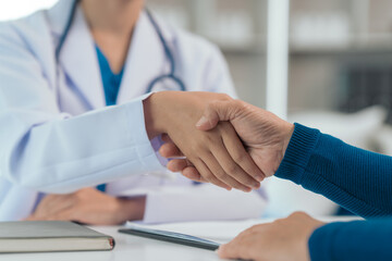 Shaking hands together of Asian people experienced female doctor giving advice to elderly male patient cancer and x-ray results and treatment options, Cancer Support, Informed Choices - obrazy, fototapety, plakaty