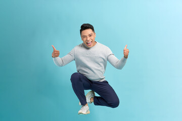Full length photo of confident pretty man jumping high thumbs up empty space