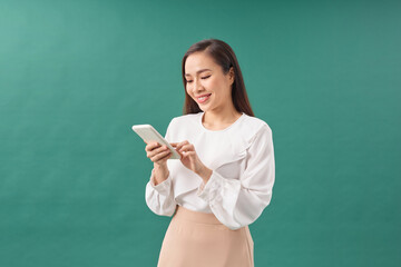 Young asian girl using smartphone typing message smiling with a happy and cool smile on face