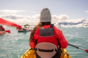 Poster kayaking in Iceland next to an iceberg © Nilton