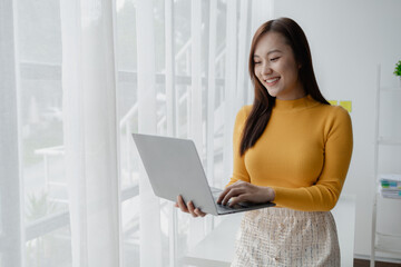 Young Asian business woman dialing a telephone, business woman working in finance, planning finances for a startup company and reviewing financial statements. Financial management concepts.