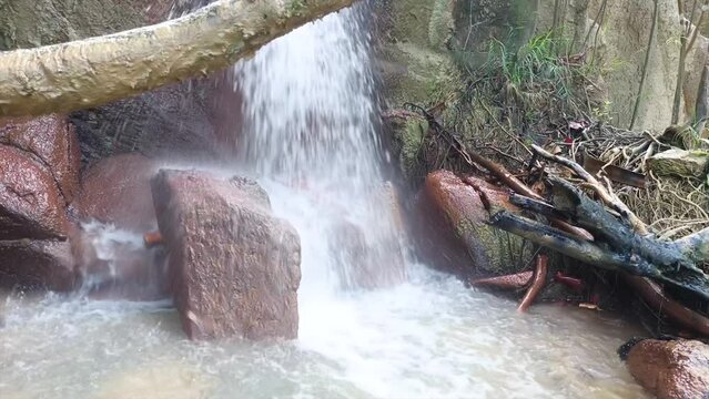 The Flow Of A Waterfall That Falls And Breaks On River Rocks, In Daya Baru Village, Indonesia