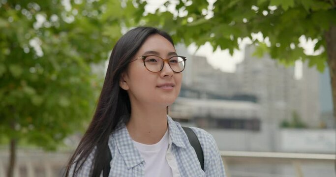 Young asian woman wearing casual clothes with backpack on the back walking at the city