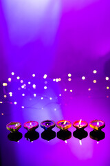 Close up of six diwali candles with copy space on purple background
