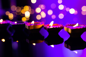 Close up of five diwali candles with copy space on purple background