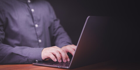 Man entrepreneur use laptop computer working at night. Male hands typing on the laptop keyboard. Business and technology concept of freelance work, work from home, businessman working at home office.