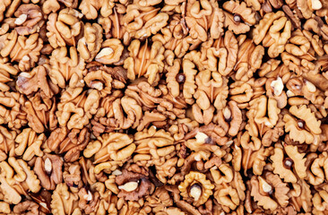 Fototapeta premium Halves of walnut kernels form the background.