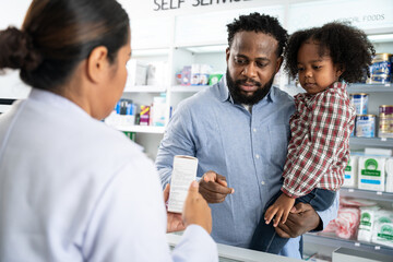 Pharmacist talking with customer at pharmacy counter. She tells customers about drug information at the pharmacy. - obrazy, fototapety, plakaty