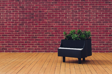 Creative composition made of piano and green leaves against red brick wall background. Minimal musical instrument concept. Trendy piano and green plants idea. Musical background aesthetic.