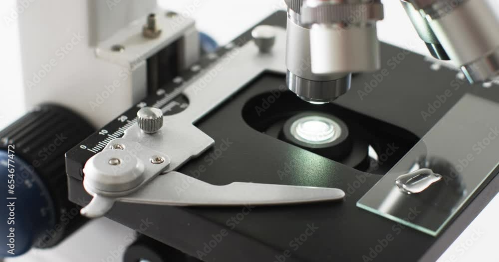 Poster video of close up of laboratory microscope with copy space on white background