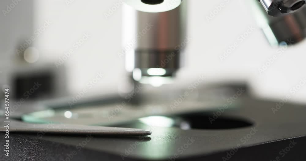 Poster video of close up of laboratory microscope with copy space on white background