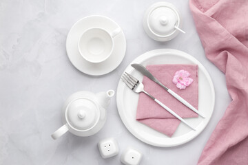 White ceramic tableware and cutlery. Utensil dishware, crockery, teapot and cup on grey marble...