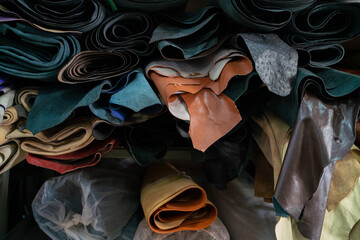 Colorful raw genuine vegetable tanned leather on shelf in crafts shop