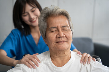 Senior woman being massage by nurse at hospital. She feeling happy and relax with massaging in...