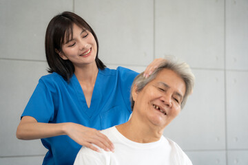 Fototapeta premium Senior woman being massage by nurse at hospital. She feeling happy and relax with massaging and sitting on wheelchair at hospital.