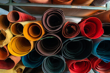 Colorful raw genuine vegetable tanned leather on shelf in crafts shop