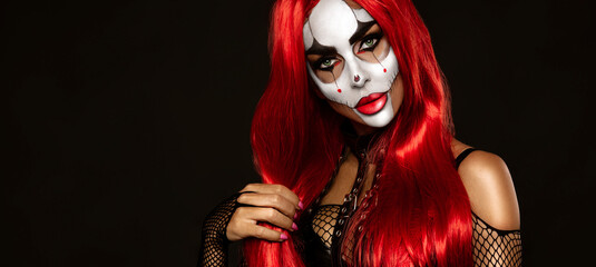 Sexy woman in a Halloween makeup and costume on black background. Halloween makeup and costume concept.