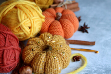 Cozy autumn crochet. Close  up photo of handmade amigurumi toys made of natural yarn. Cute decorations for autumn holidays. Hobbies and leisure concept. 