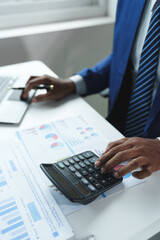 A male accountant or a business man uses a laptop to calculate investment results. And making...