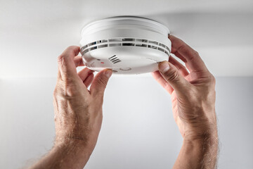 Home smoke and fire alarm detector installing, checking, testing or replace battery - obrazy, fototapety, plakaty