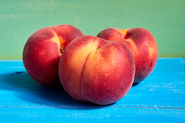 Ripe peaches in the bright sun on a blue background