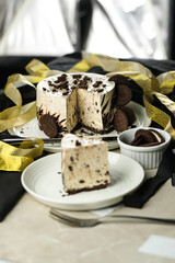 Oreo Cheesecake slice include chocolate, cream, sugar with fork and flowers served in plate isolated on napkin side view of cafe food