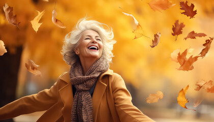senior woman in autumn twirling leaves in an autumn park - obrazy, fototapety, plakaty