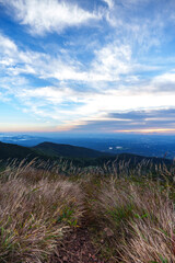 夜明けの朝日に照らされて輝く雲と青空と那須岳の登山道　栃木県那須