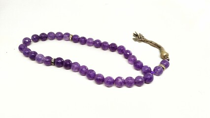 Purple agate stone prayer beads tasbih on a white background