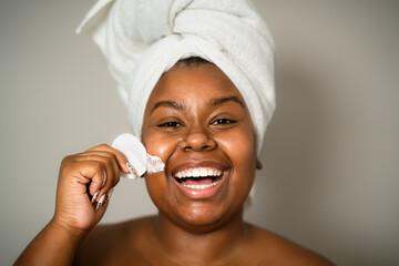 Happy curvy African woman having skin care spa day - People self care lifestyle concept