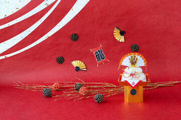 日本の正月　鏡餅と扇と竜の文字の凧と水引のデザイン（赤和紙背景・波型合成）