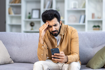 Man received bad news message with sad news online while sitting on couch in living room using app...