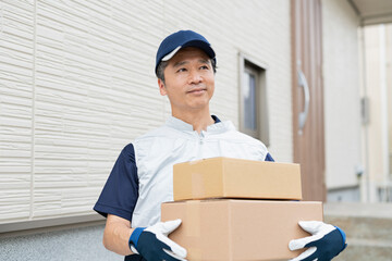 荷物を運ぶ40代配達員