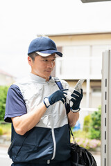 給湯器の写真を撮る作業員の男性