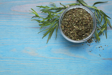 Fototapeta na wymiar Dry and fresh tarragon on light blue wooden table, flat lay. Space for text